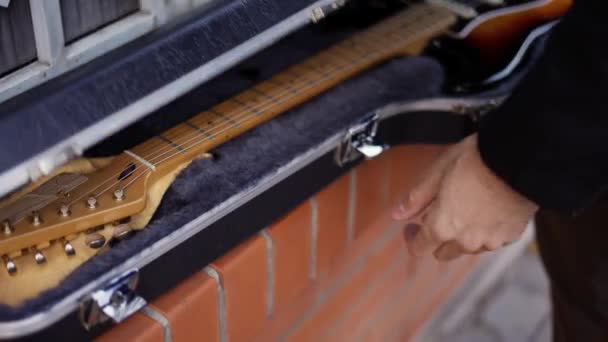 Facet wyciąga gitarę z futerału. — Wideo stockowe