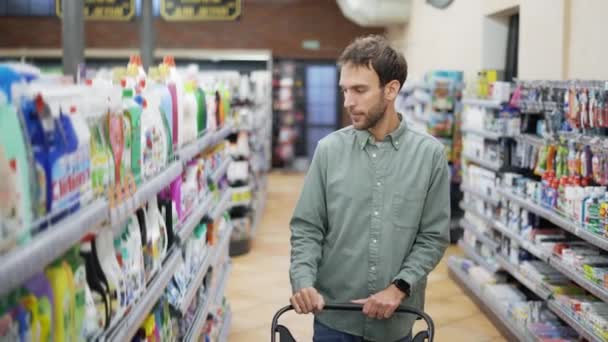 Man walks through the supermarket and takes goods from the shelf — Stock Video