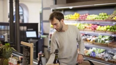 Adam yiyecek rafından taze böğürtlen alıyor. Alışveriş yapan kişi markette yabanmersini seçiyor.