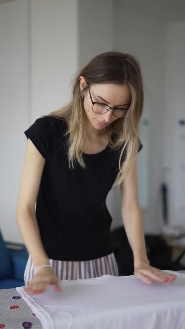 Woman ironing clothes at home on board, close up — Stockvideo