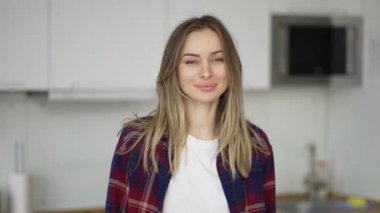 Beyaz mutfaktaki çekici sarışın kadın portresi.