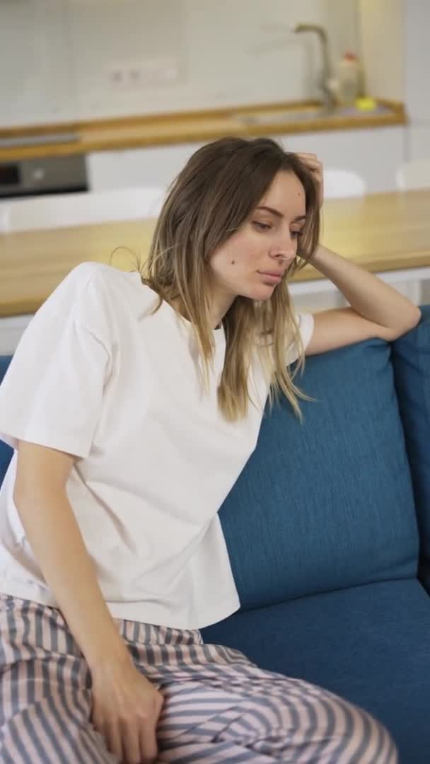 患抑郁症或困倦的年轻妇女坐在沙发上 — 图库视频影像