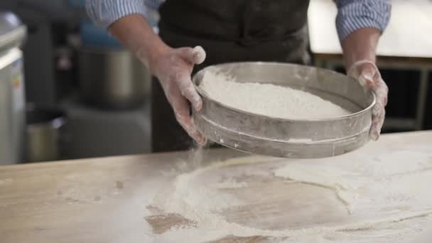 Hands holding sieve and sifting flour at the kithen. Close up, indoor, slow motion — Stock video