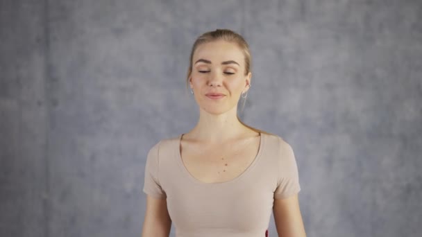 Retrato de una atractiva entrenadora de yoga que hace Namaste gesto a mano — Vídeos de Stock