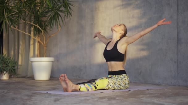 Female coach yoga practicing yoga or stretching in loft studio on mat — Stockvideo