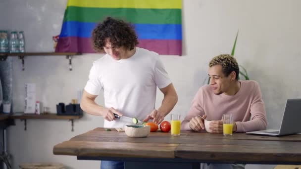Par gay på köket tillsammans förbereder frukost, lgbt flagga på bakgrunden — Stockvideo