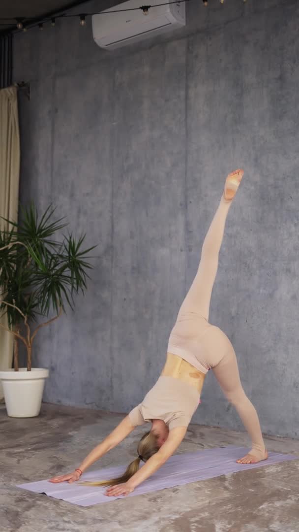 Vrouwelijke coach yoga beoefenen van yoga, staande in Single Leg naar beneden gericht hond houding, Eka Pada Adho Mukha Svanasana — Stockvideo