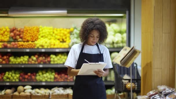 Afro-Amerikaanse vrouwelijke personeel persoon staande met tablet in supermarkt — Stockvideo