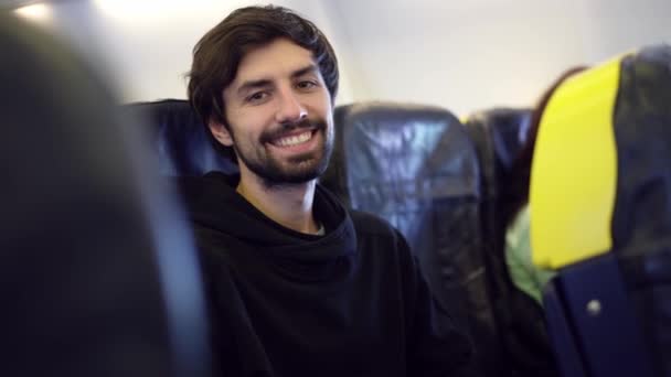 Uomo godendo il suo viaggio in aereo, sorridendo alla macchina fotografica — Video Stock