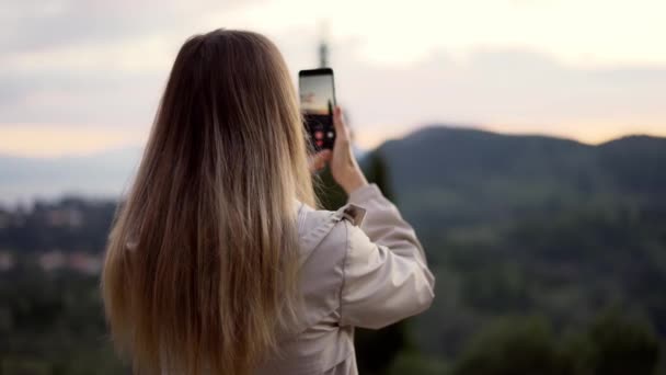 Blondynka robi zdjęcie gór ze smartfonem w rękach — Wideo stockowe