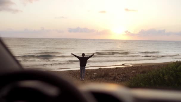 En man kom för att se havet, glatt gående till det. Bilder från bilen — Stockvideo