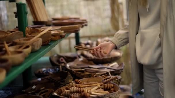 Turystka robi zakupy na miejskim bazarze, szuka drewnianych przedmiotów rękodzielniczych — Wideo stockowe
