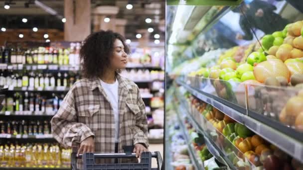 Afro-Amerikaanse vrouw kiest pomelo in supermarkt — Stockvideo