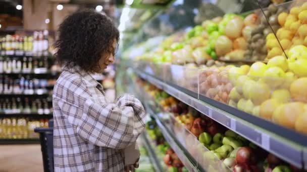 Donna sorridente che sceglie frutta fresca nel supermercato in sacchetto di carta — Video Stock