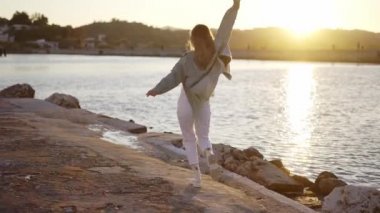 Sarışın kadın yavaşça taş denizlerde yürüyor.