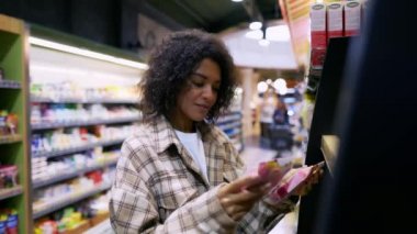 Kıvırcık kadın paketler, ürünler ve alışveriş malzemeleri okur.