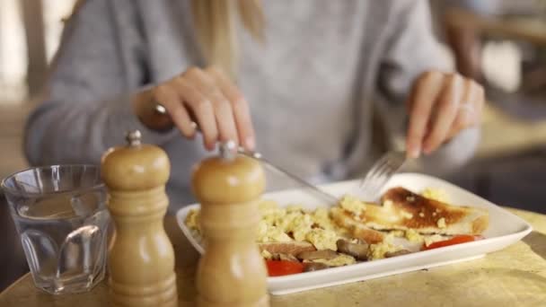 만족 해 하는 아름다운 아가씨 가 카페에서 맛있는 음식을 씹는 모습 — 비디오