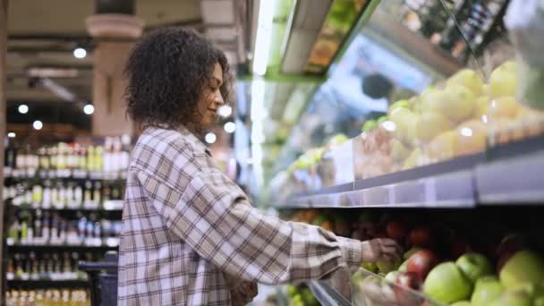 Mujer alegre elegir manzanas frescas en el supermercado en bolsa de papel — Vídeos de Stock