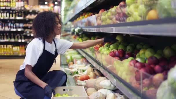 Gekrulde vrouw rangschikken grote groene appels op plank, slow motion — Stockvideo