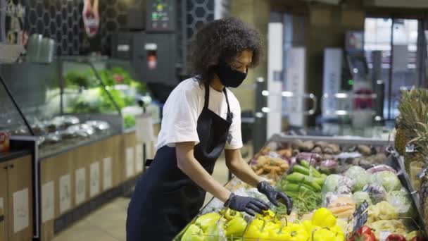 혼합 인종 식료품 점 직원 얼굴 마스크와 신선 한 야채와 과일을 넣는 장갑 — 비디오