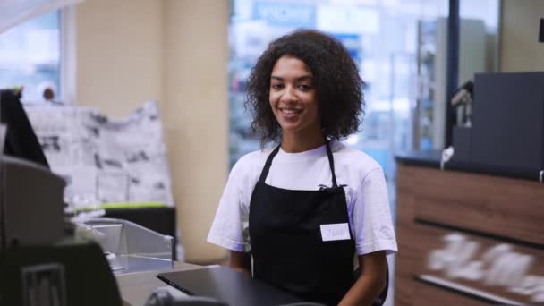 Portrait d'un travailleur afro-américain à la caisse de l'épicerie, sourire amical — Video