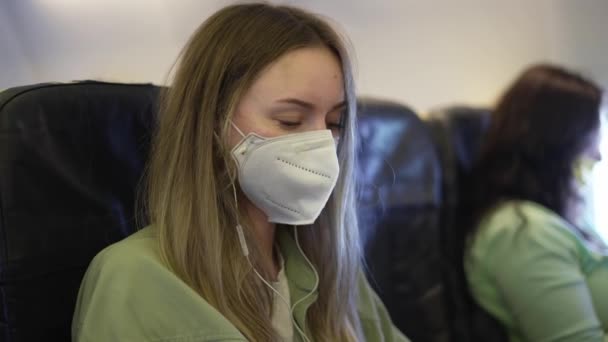 Mulher no avião ouvir música em fones de ouvido usando telefone celular — Vídeo de Stock