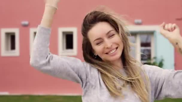 满意的女士在新家门外手握新公寓钥匙跳起舞来 — 图库视频影像