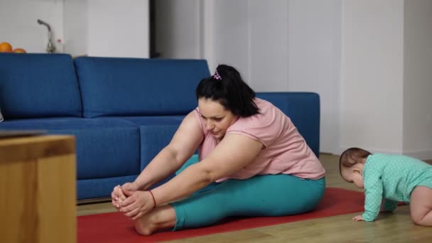 Överviktig kvinna gör övningar medan hennes barn leker bredvid henne — Stockvideo