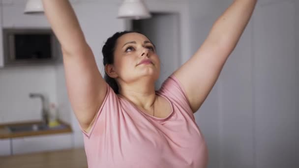 Młoda atrakcyjna plus rozmiar kobieta praktykuje jogę, trzymać się za ręce w namaste — Wideo stockowe