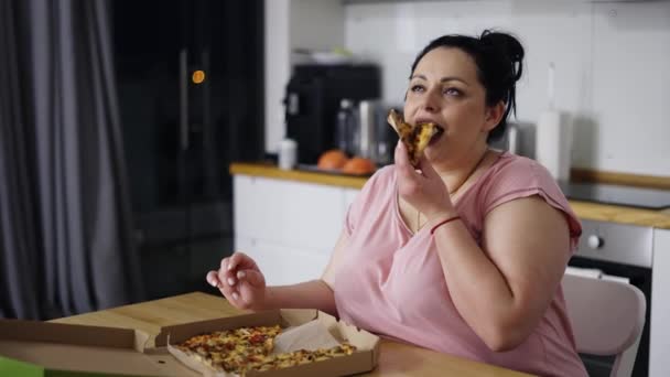 Mujer sobrecargada come con gran placer, mujer come pizza, rueda los ojos, cámara lenta — Vídeos de Stock