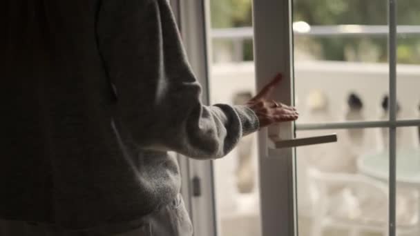 Жінка закриває штори і терасні двері в готельному номері — стокове відео