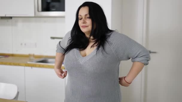 Schöne Frau fühlt sich glücklich, nachdem sie ihre Taille zu Hause gemessen hat — Stockvideo
