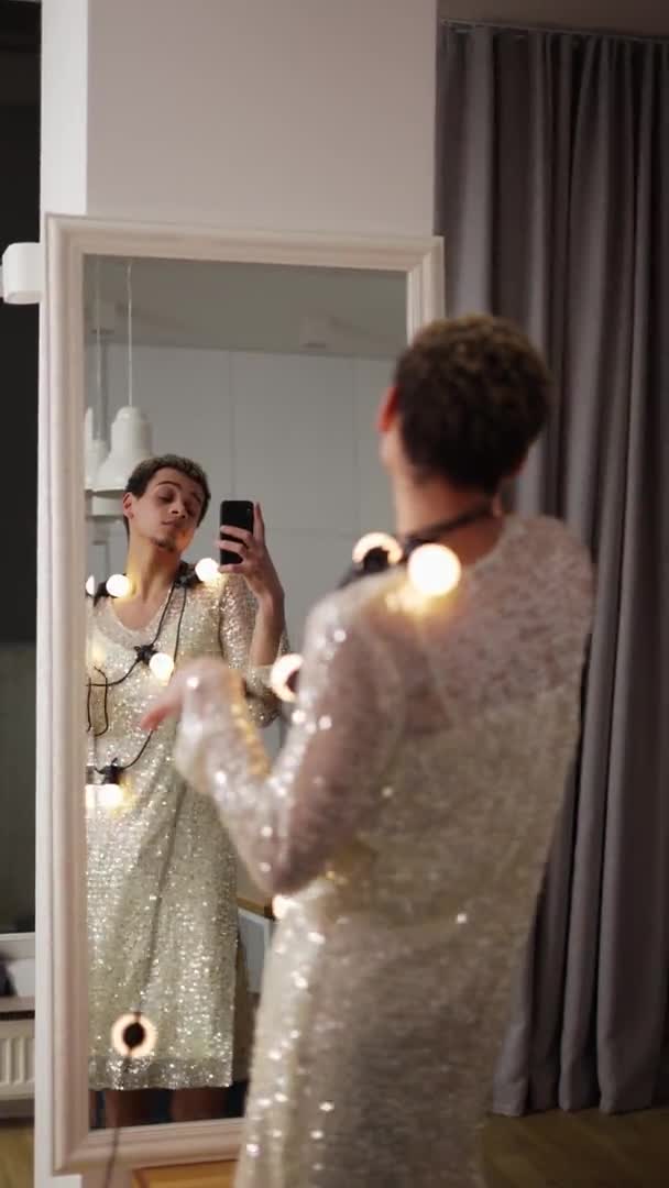 En man i klänning poserar framför spegeln med krans på halsen, sensuellt flyttar — Stockvideo