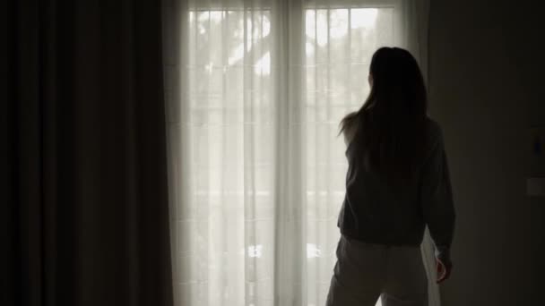 Γυναίκα ανοίγει κουρτίνες στο δωμάτιο του ξενοδοχείου βγαίνει στο μπαλκόνι, τραβώντας τα χέρια ψηλά — Αρχείο Βίντεο