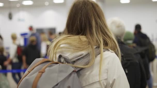 Kobieta podróżująca w czarnej masce czeka na odprawę na lotnisku — Wideo stockowe