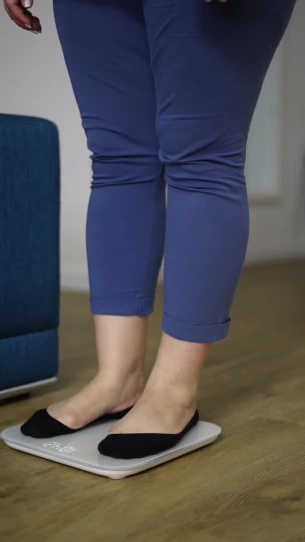 Skördade bilder av en kvinna som mäter vikt i hemmet — Stockvideo
