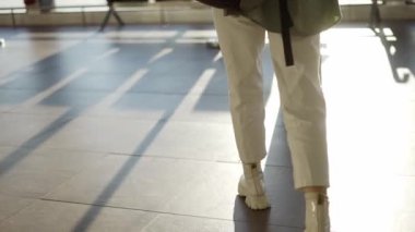 Havaalanı terminalinde sırt çantası taşıyan kadın turistin arka görüntüsü.