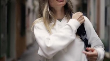 Şehirde bir turist kız, sırt çantasını omzuna takmış.