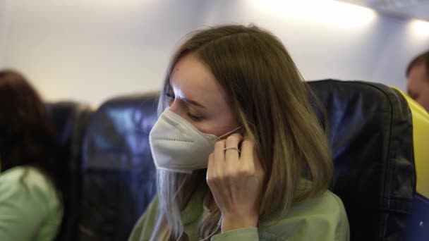 Путешественник в самолете надевает наушники, чтобы слушать музыку — стоковое видео