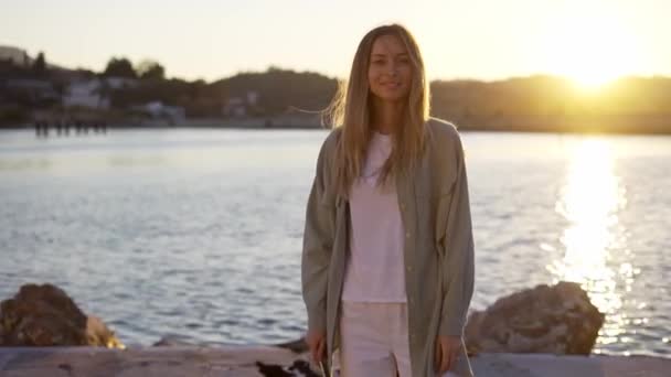 Donna bionda si trova sulla costa di pietra sorridente felicemente — Video Stock