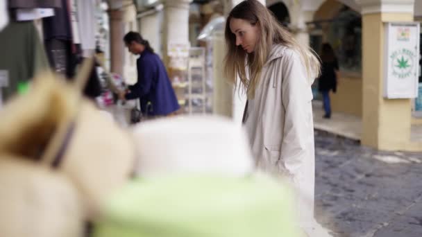 Turistkvinna shopping på stadens gata basar, ser en liten statyett — Stockvideo