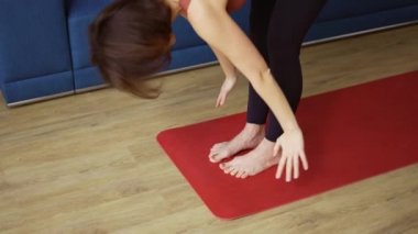 Kadın minder üzerinde yoga yapıyor. Tahta poz veriyor.