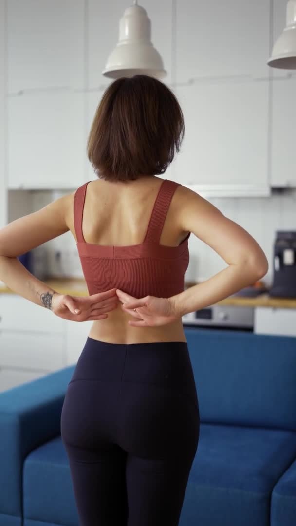 Vista trasera de una mujer conectando las manos detrás de su espalda, concepto de yoga — Vídeos de Stock