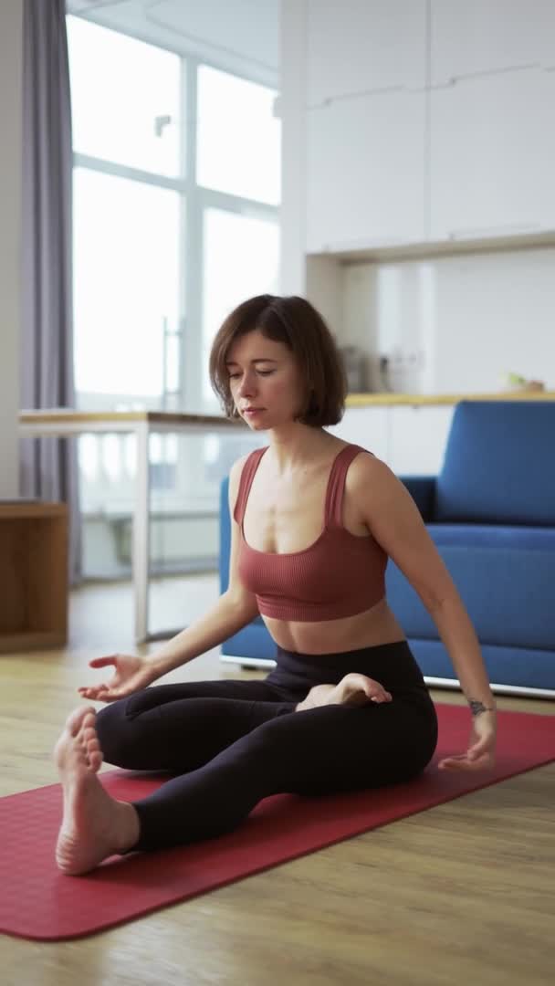 Joven morena disfruta del yoga en Forward Bend posición en la estera — Vídeos de Stock