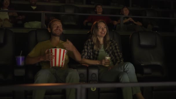 남자 친구와 여자 친구가 코미디 영화를 보면서 큰 웃음을 짓는다 — 비디오