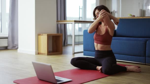 Mujer practicando yoga con entrenador vía videoconferencia, calentando articulaciones — Vídeo de stock