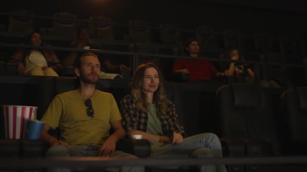 Пара зустрічається в кінотеатрі, сидячи разом — стокове відео