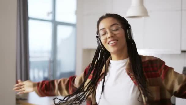 Retrato da jovem afro-americana usando fones de ouvido ouvindo a música em casa — Vídeo de Stock