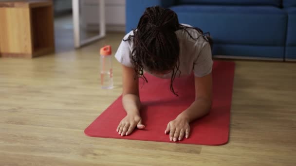African american young sportswoman doing plank exercise at home — Stock Video