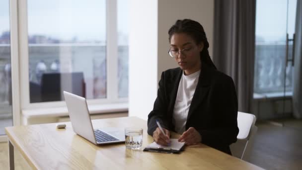 アフリカ系アメリカ人の女の子秘書ビジネス女性がオフィスのテーブルに座って — ストック動画